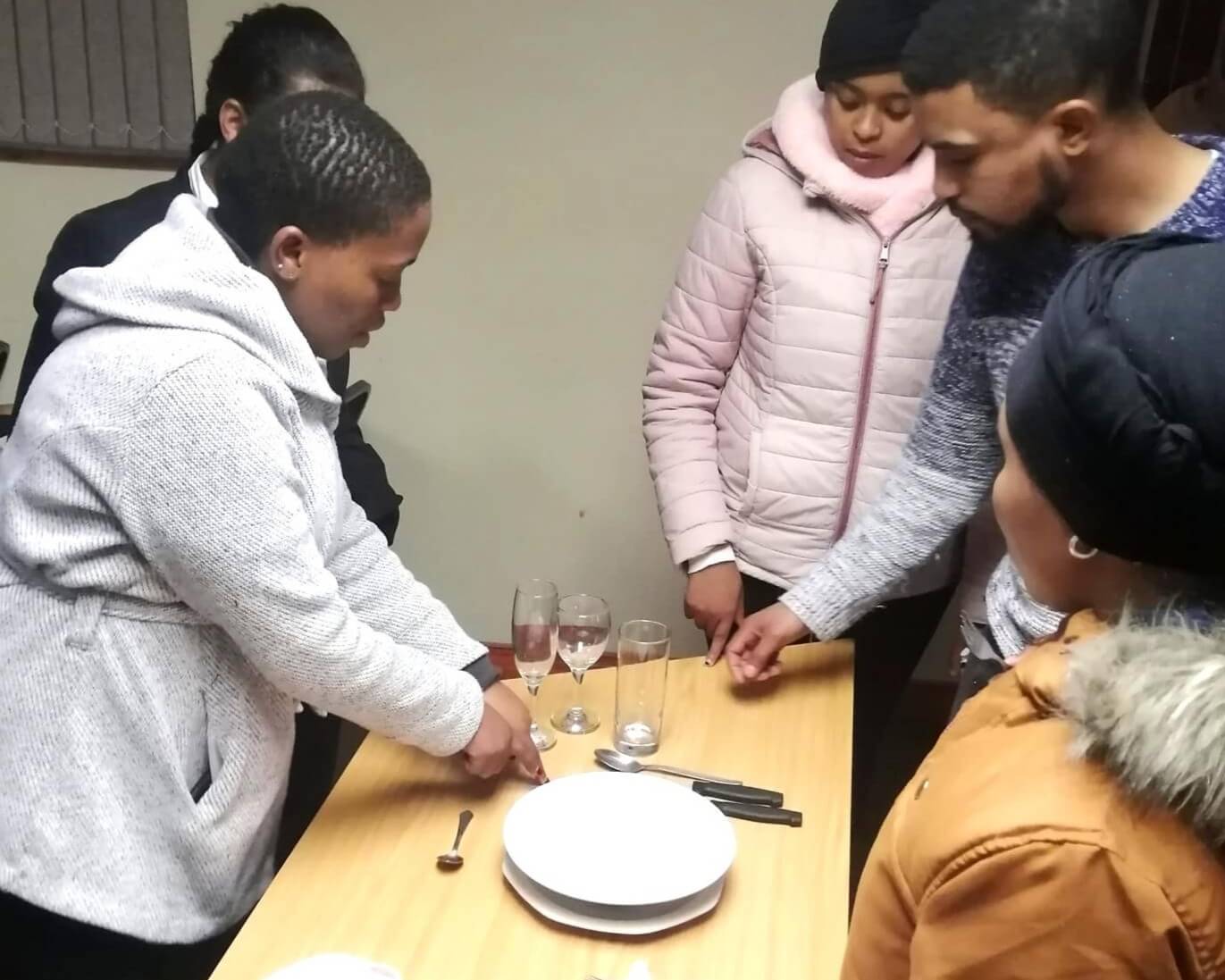 Women and men learning cutlery placement